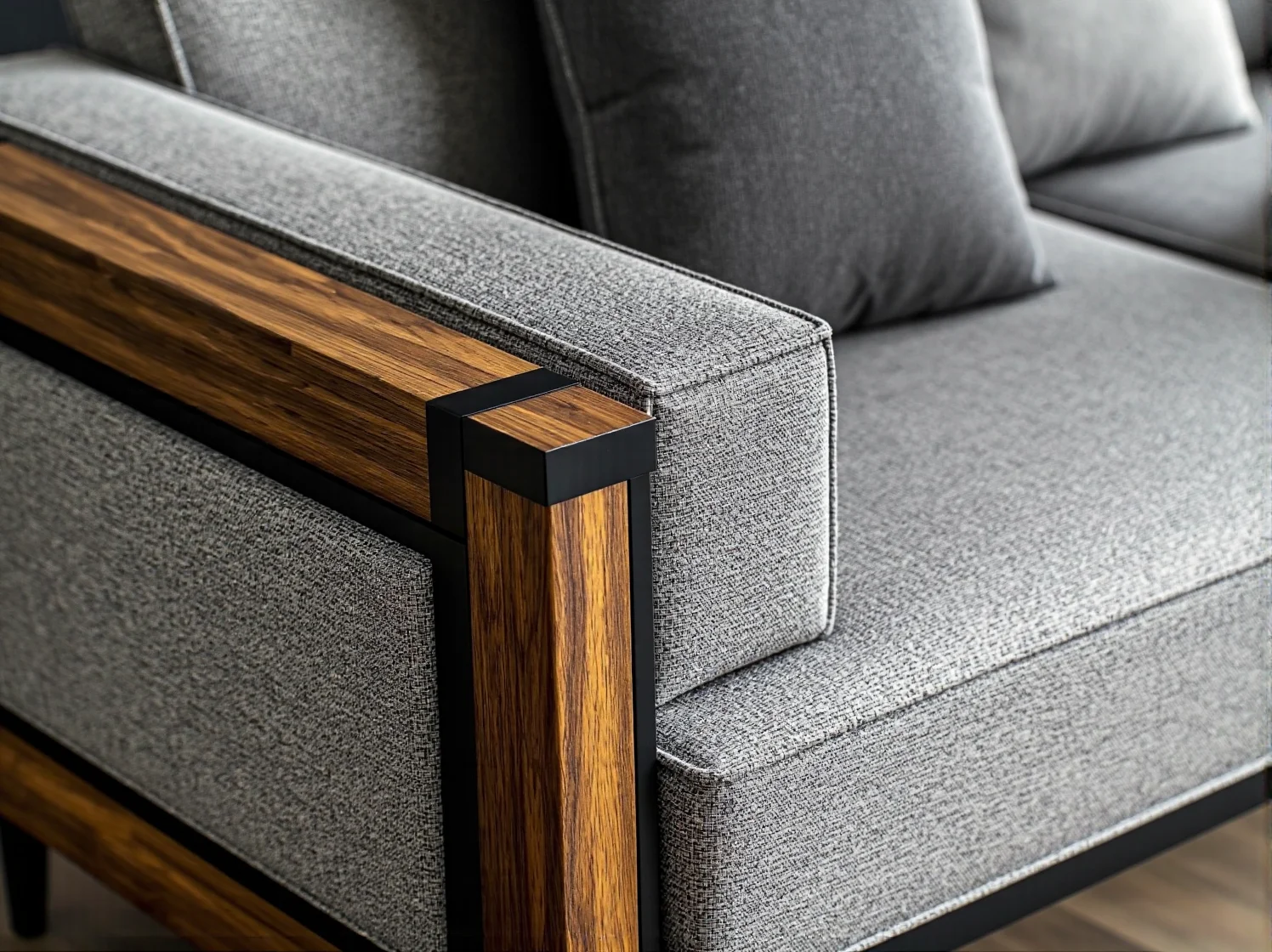 Szara sofa z drewnianymi podłokietnikami i metalową ramą