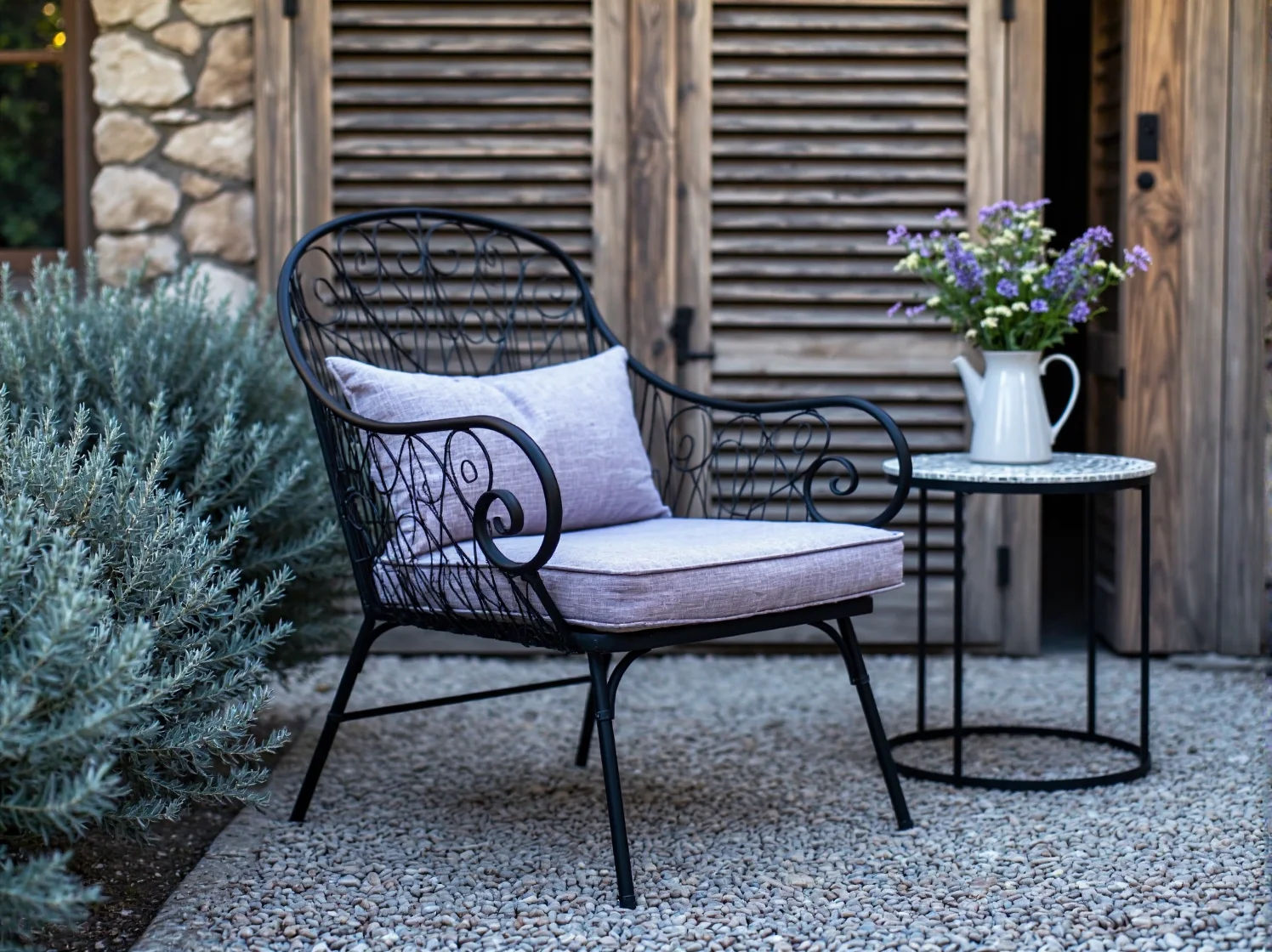 Meble ogrodowe z kutego żelaza w sielskim zakątku ogrodu prowansalskiego.